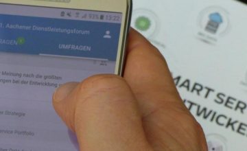 Ein Gast des 21. Aachener Dienstleistungsforum bearbeitet eine Umfrage an seinem Smartphone zum Thema "Smart Services entwickeln"