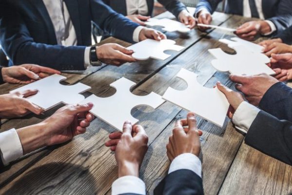 Workshop Symbolbild | Business Manager mit großen Puzzlen